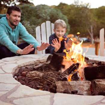 Father and son enjoying a fire in their backyard