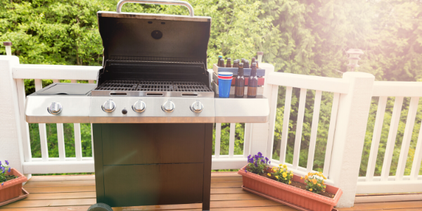 summer deck party with a grill and six pack of beer