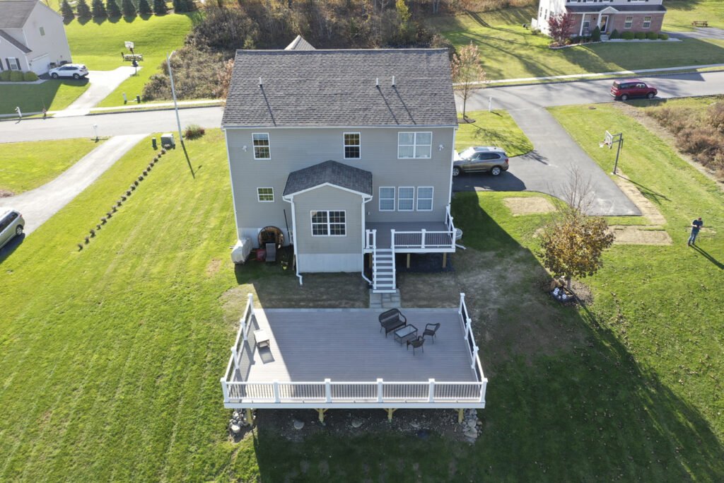 aerial view of newly remodeled deck on large hill overlooking tree grove