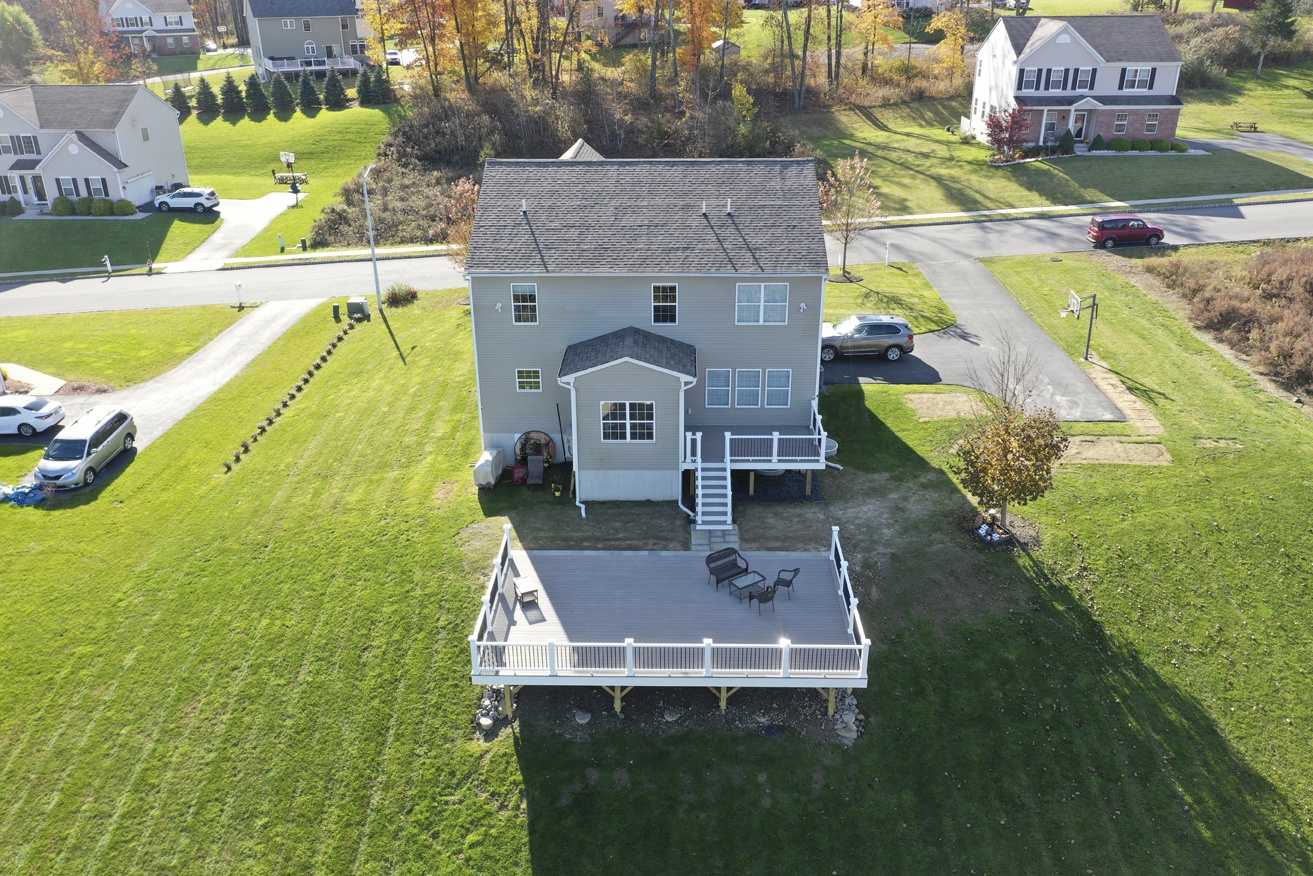 aerial view of newly remodeled deck on large hill overlooking tree grove