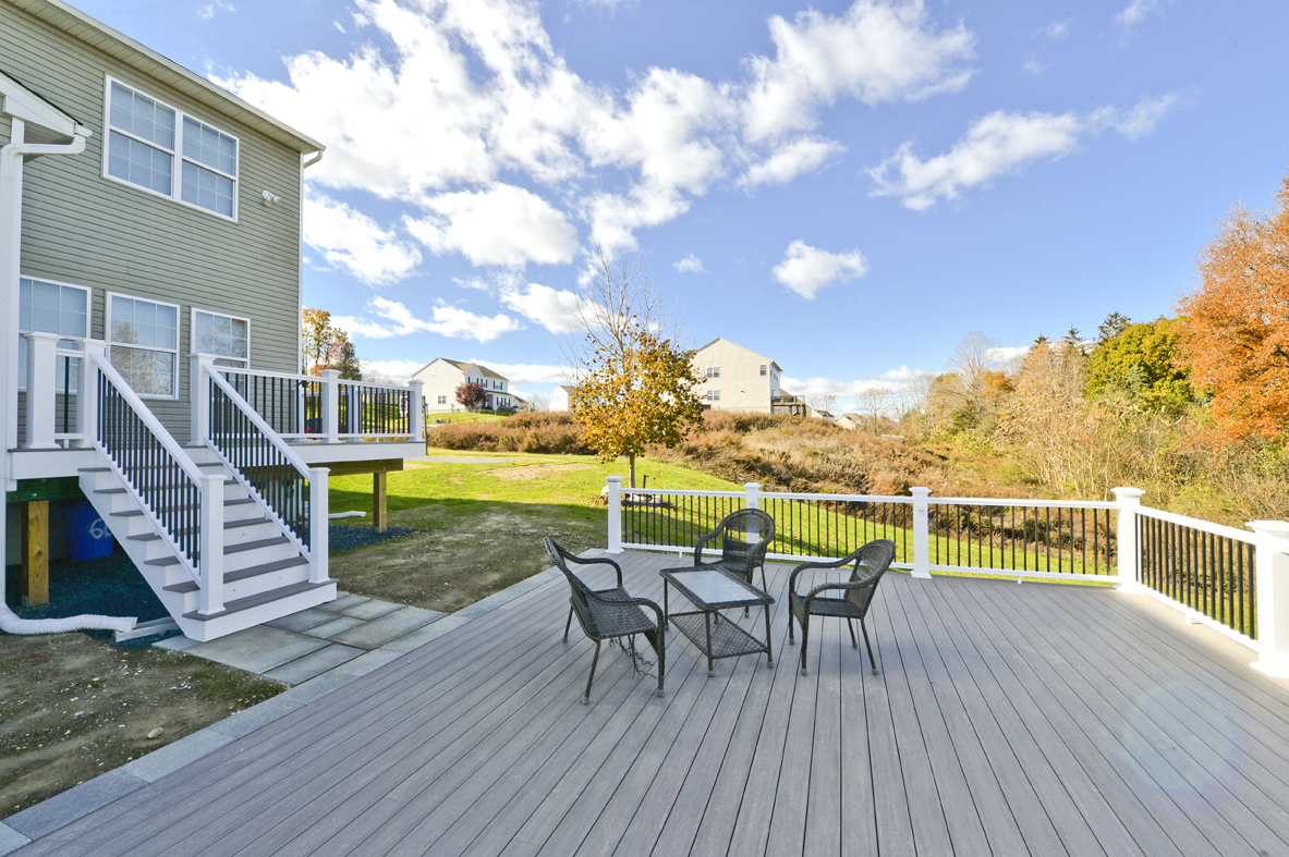 large deck with gray azek decking material and picnic table set up with blue skies in the distance